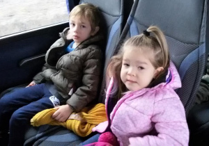 Widok na chłopca i dziewczynkę siedzących w autokarze.